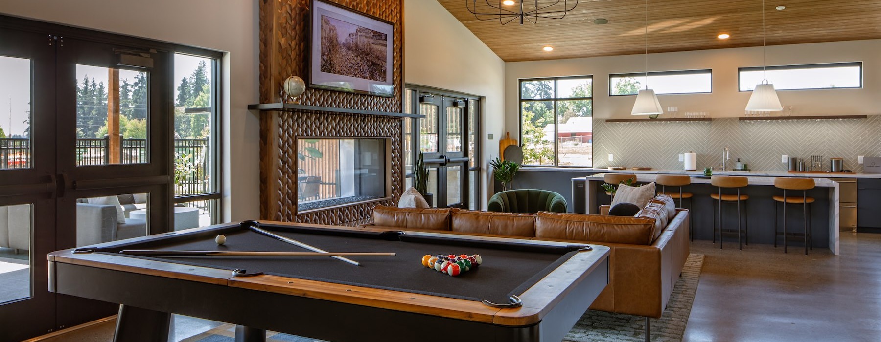 a pool table in a clubroom with a tv and couch