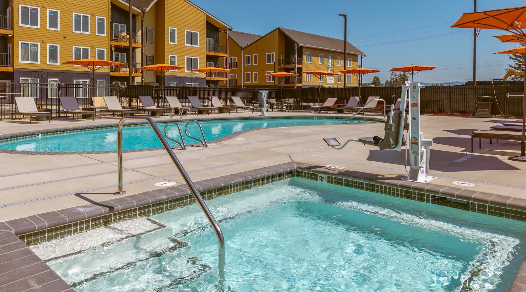 a courtyard with pools, chairs and umbrellas