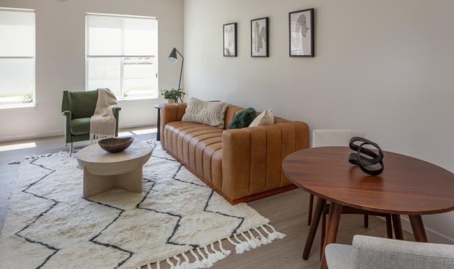 a living room with a couch, tables and chairs